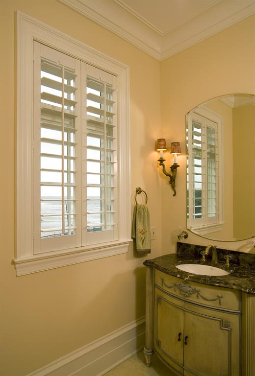 Plantation shutters in a light bathroom outlooking the ocean